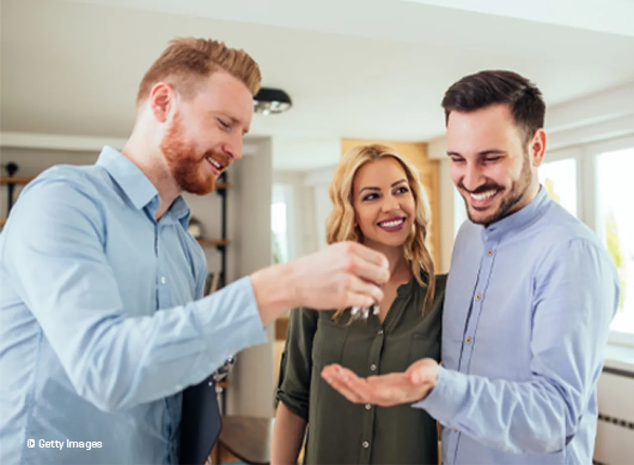 Un homme donne les clés à un couple