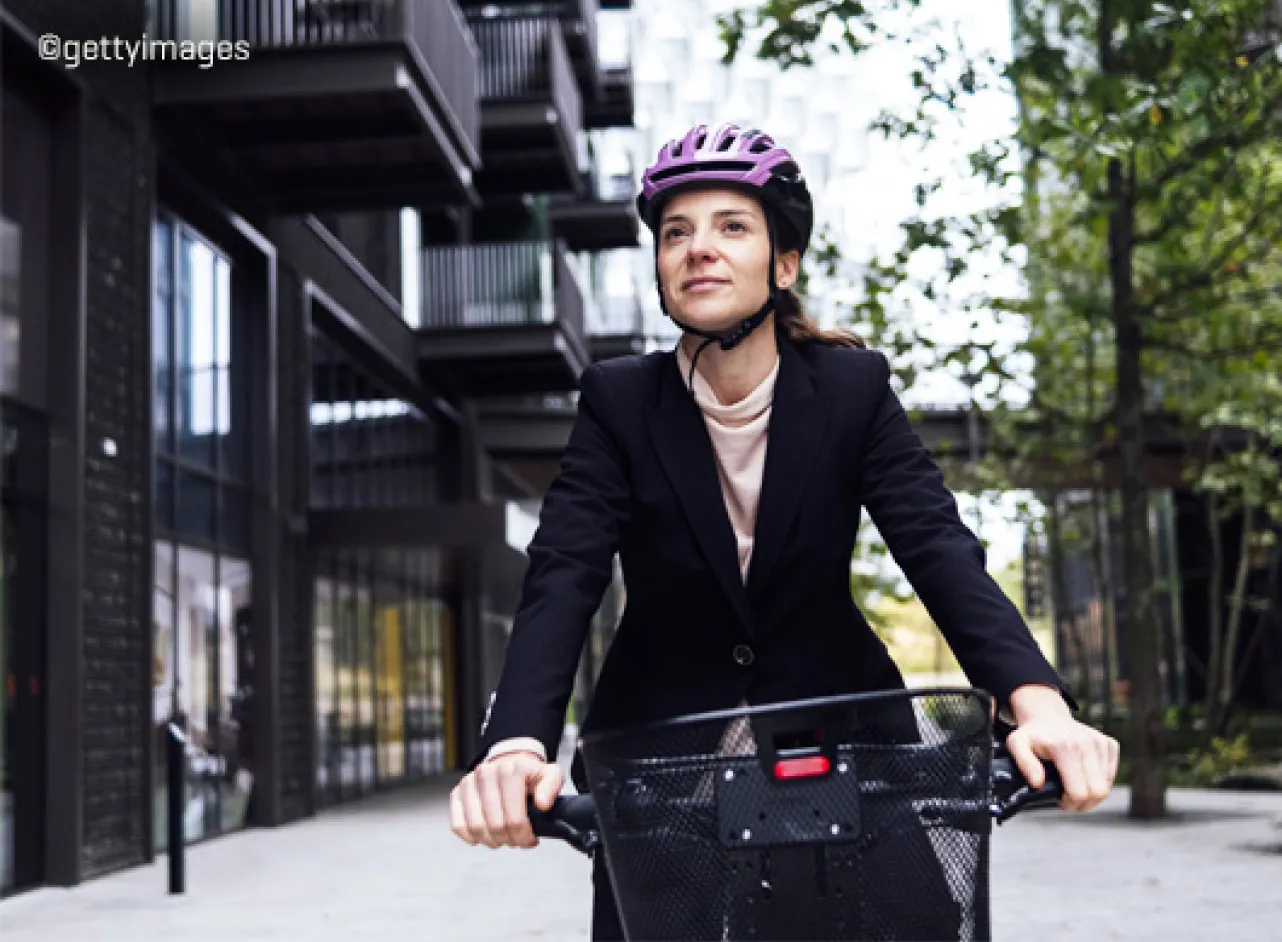 Femme à vélo avec un casque rose